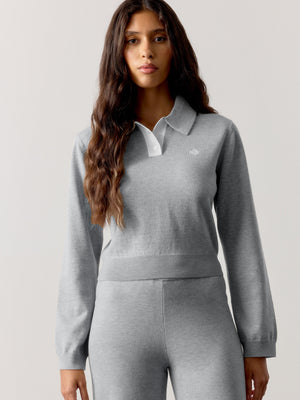 Woman wearing a grey long sleeved co-ord with a white collar against a light grey background
