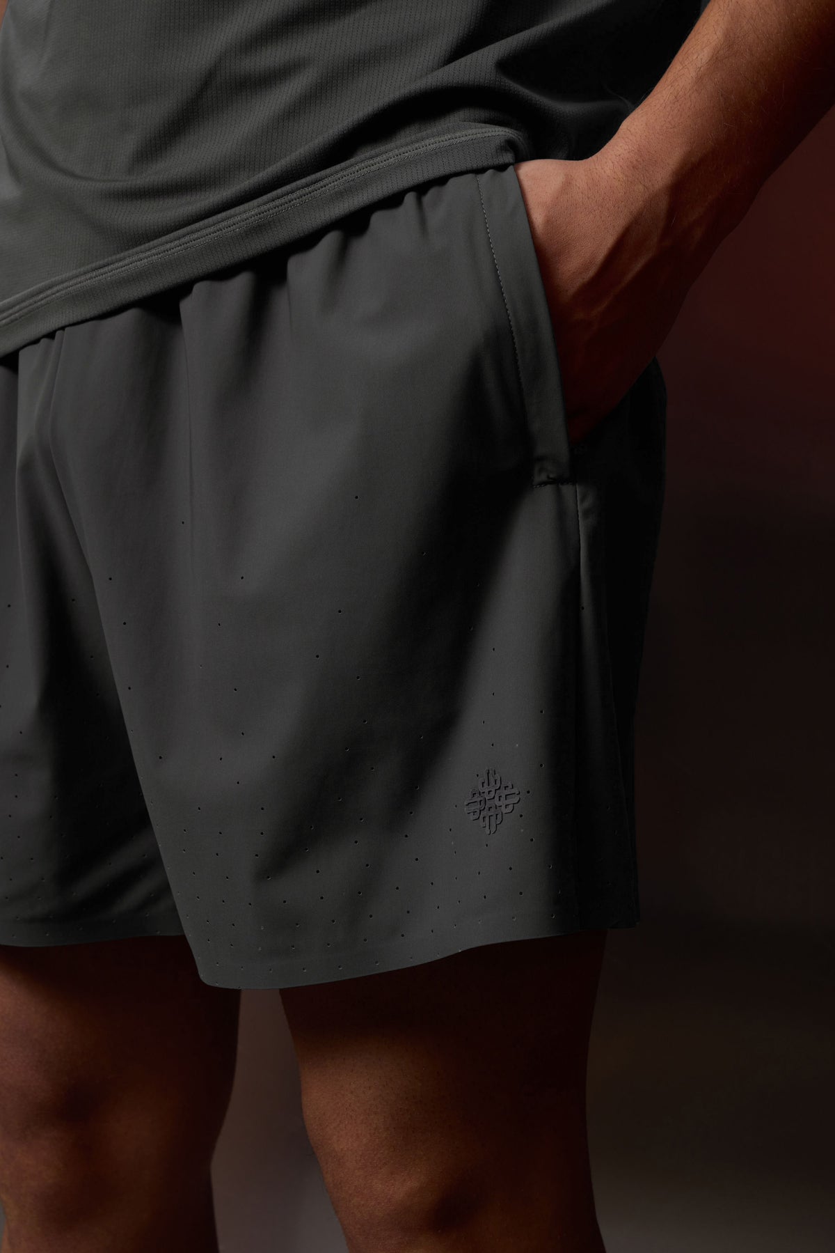 Men's Training Short in Charcoal – close-up with hand in pocket