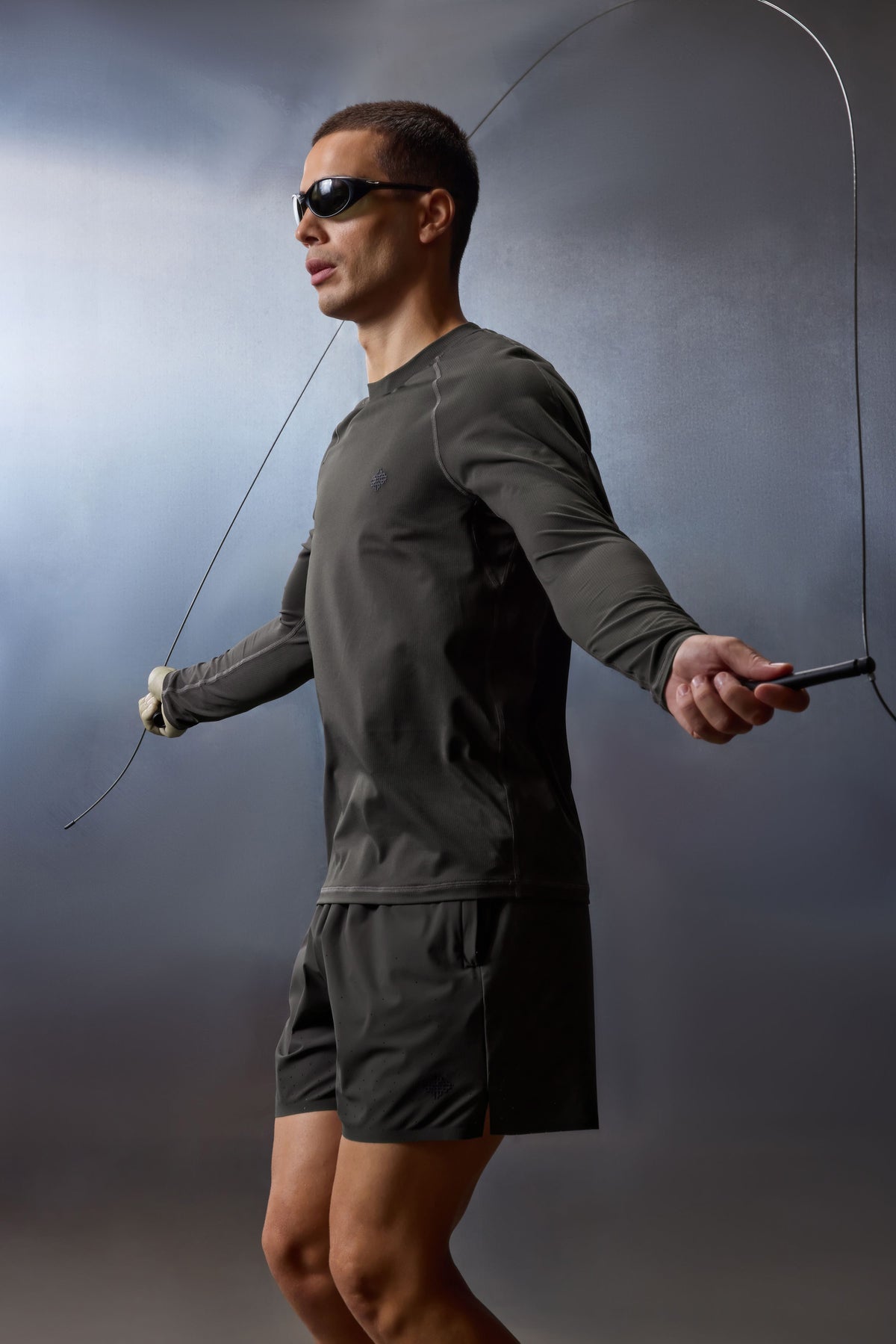 Men's Long Sleeve Training Top in Charcoal – model action shot with arm outstretched