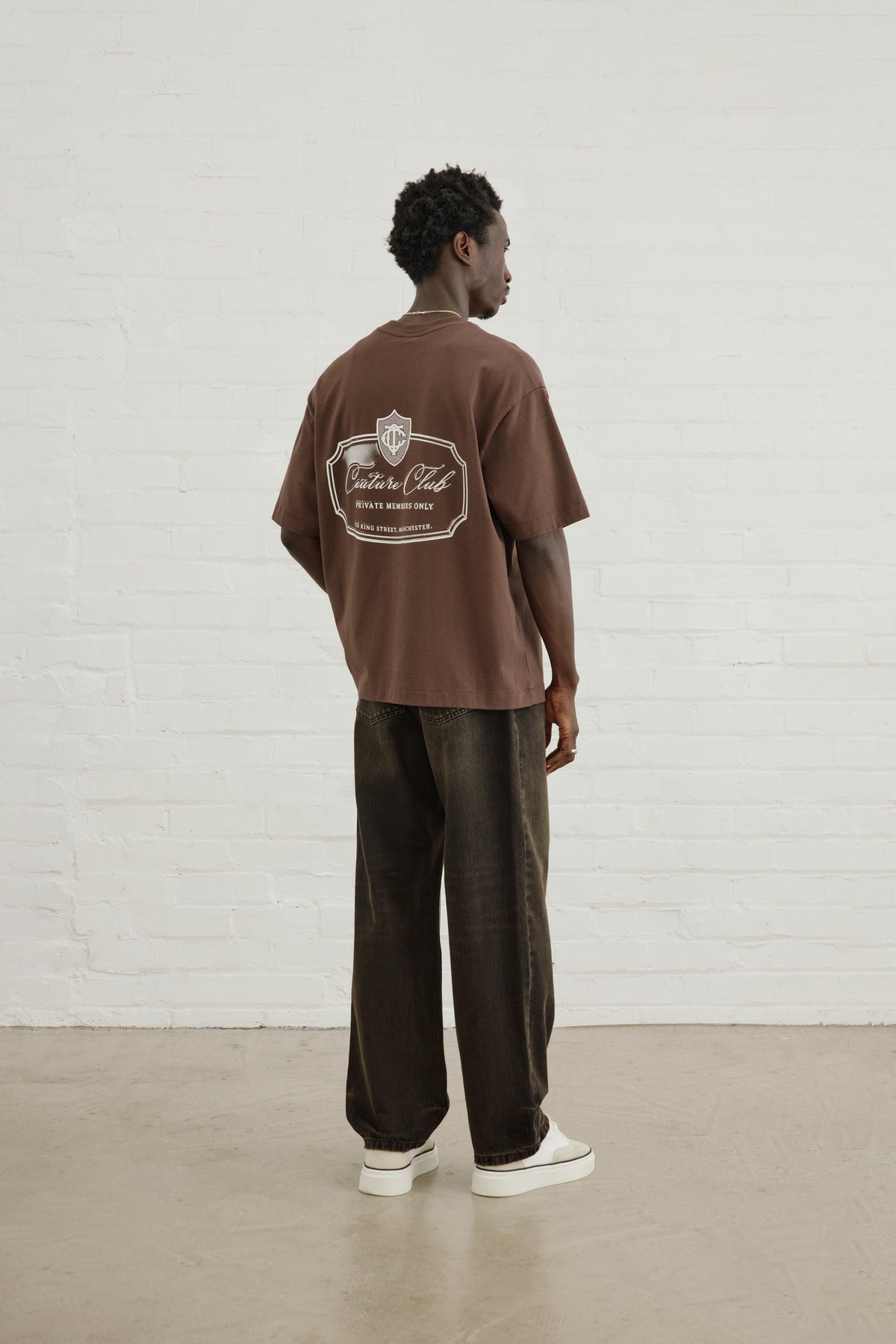 Men's Private Members Club T-Shirt in Brown – full-length model back view
