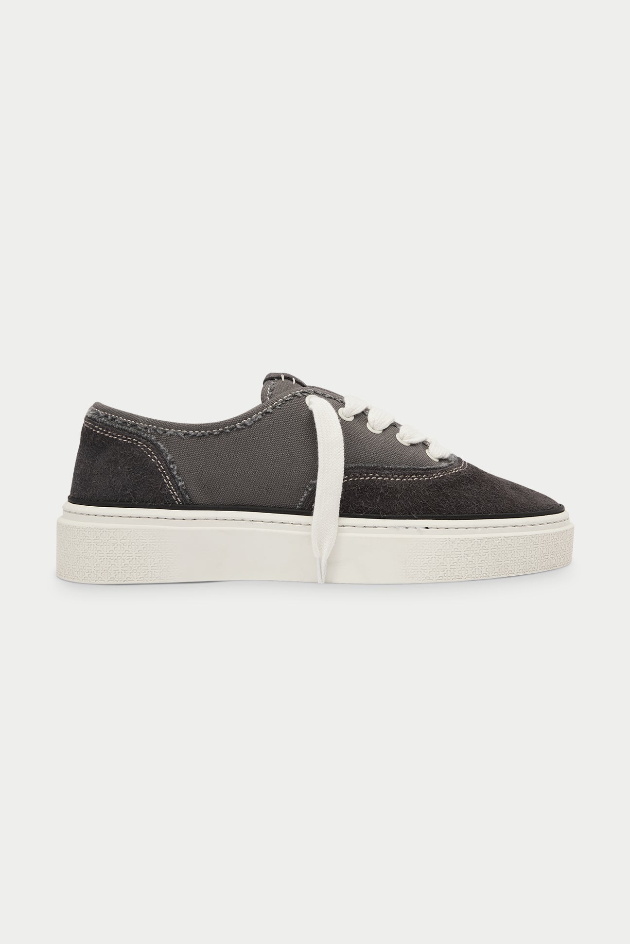 Pair of dark grey sneakers with white laces on a white background