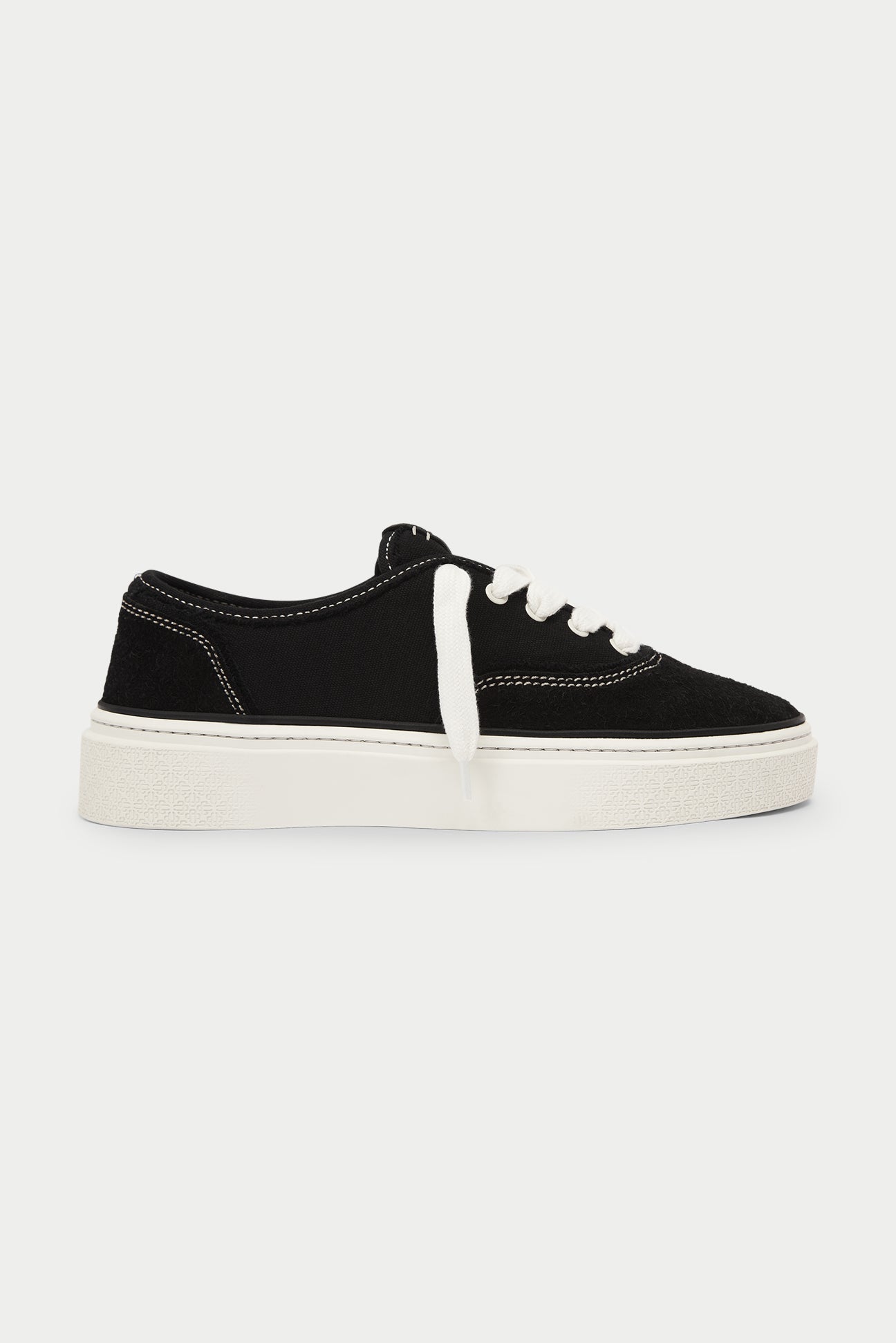Black sneaker with white sole on a white background