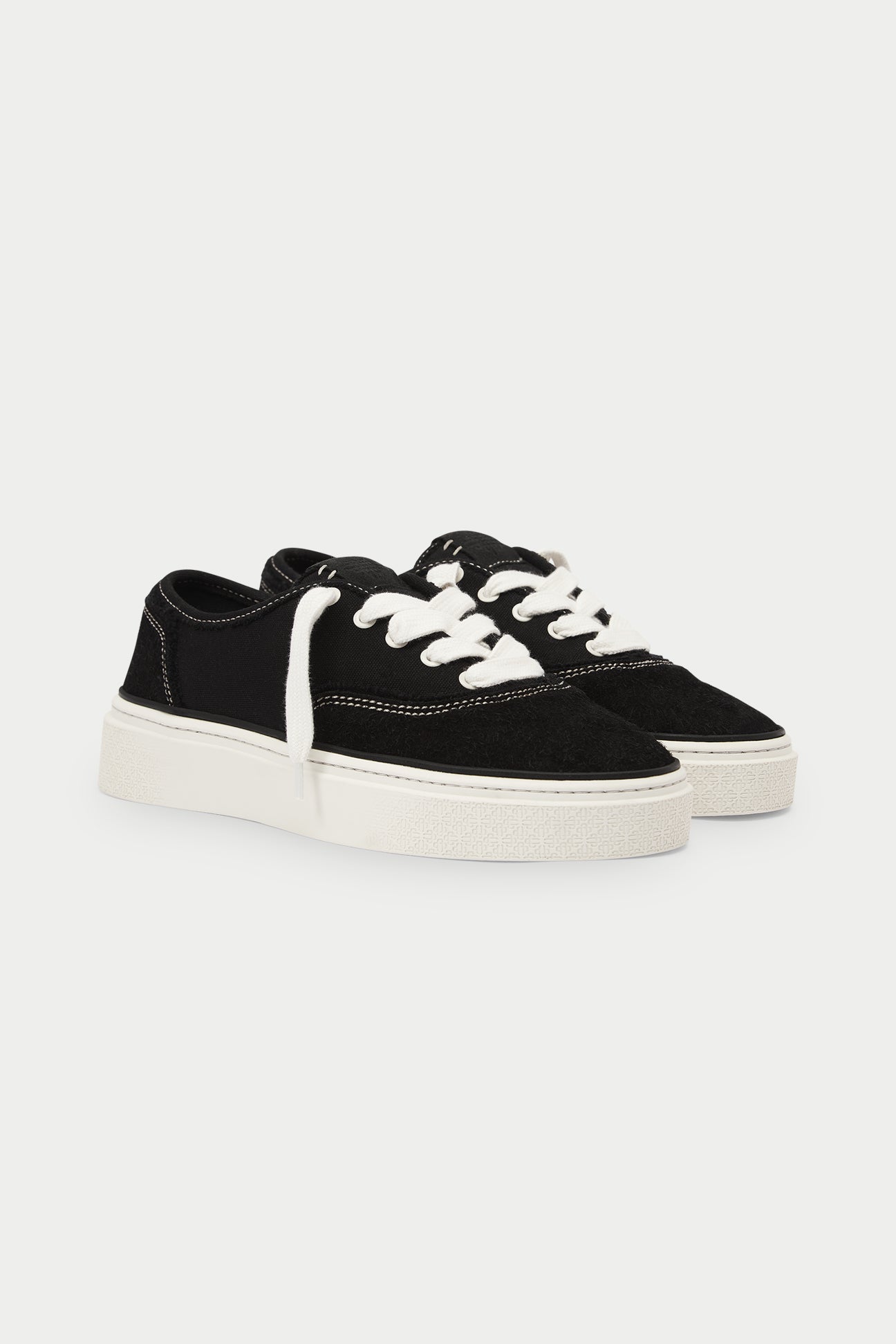 Black sneakers with white laces on a white background