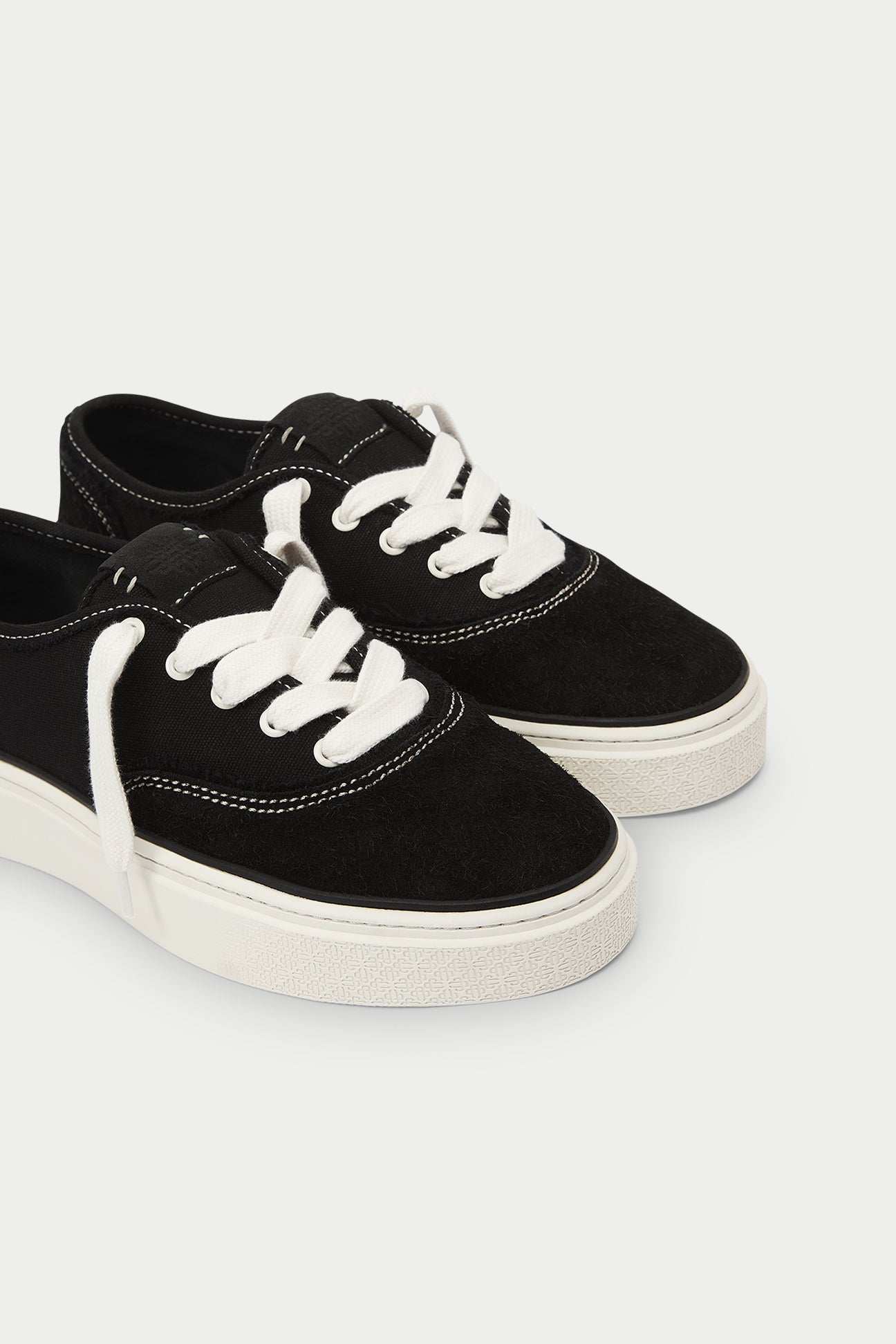 Black sneakers with white laces on a white background