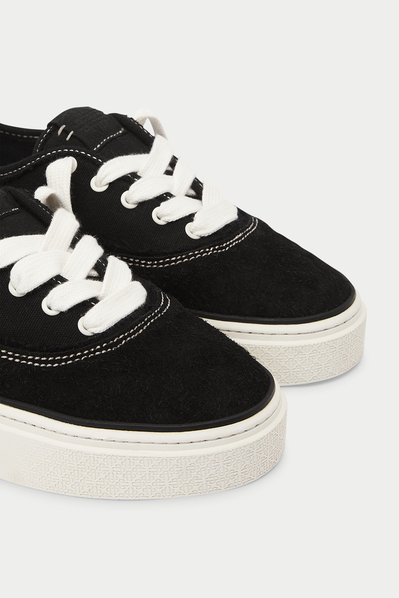 Black sneakers with white laces on a white background
