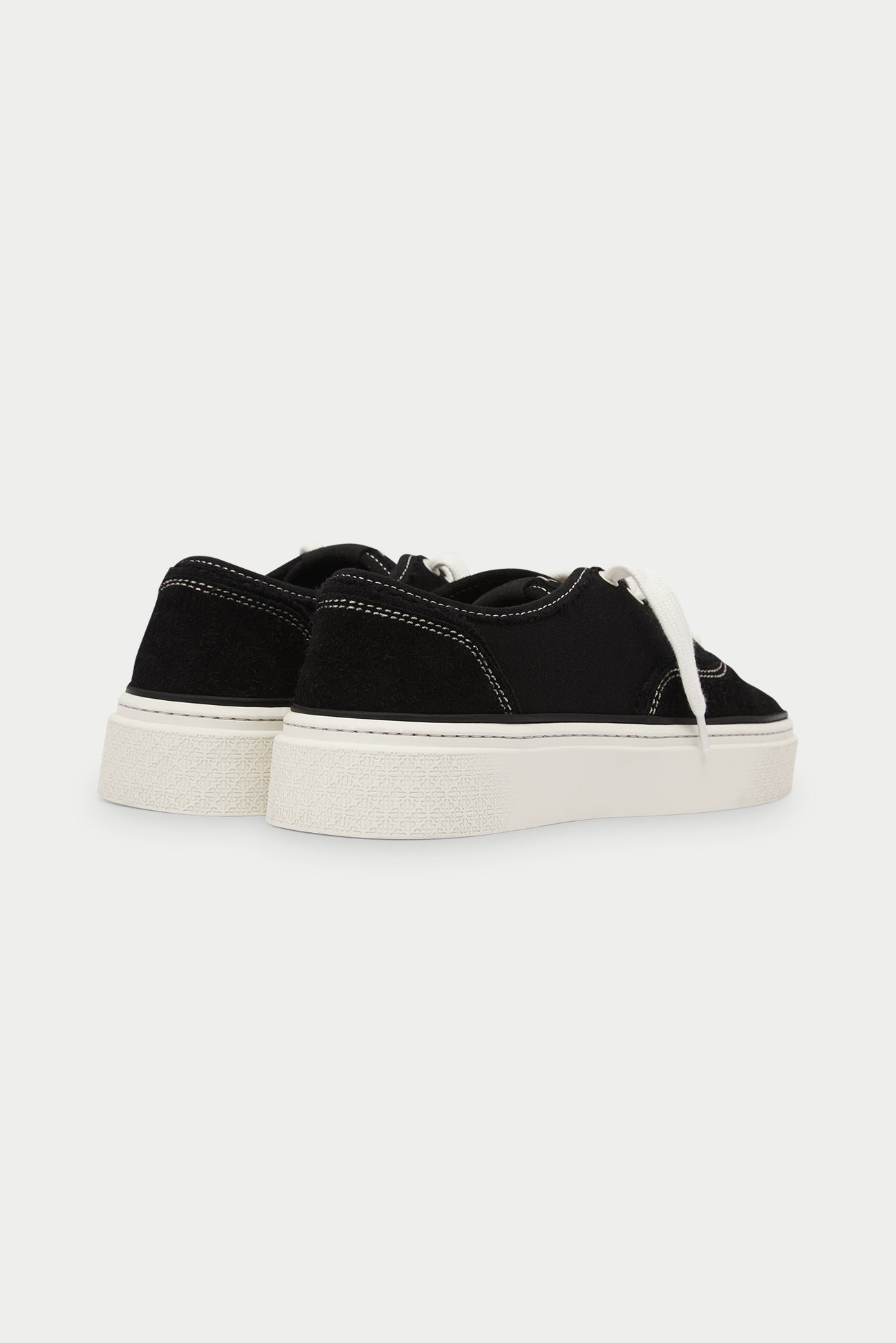 Black sneakers with white soles on a white background