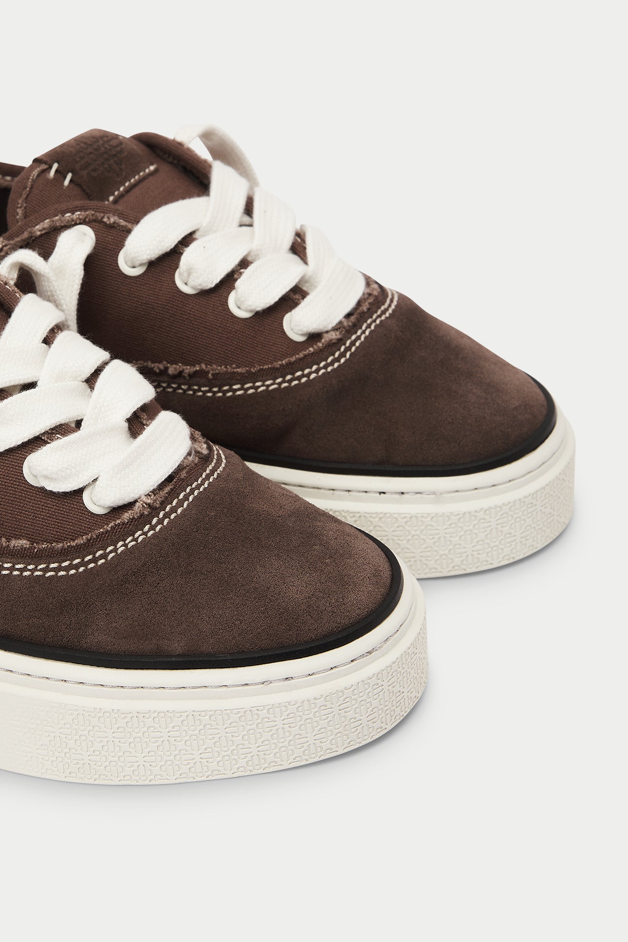 Brown sneakers with white laces on a white background