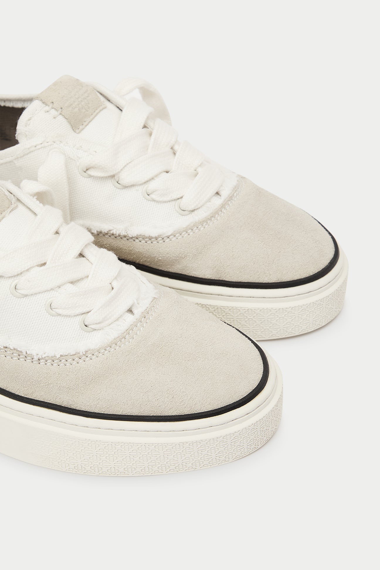 Pair of white and beige sneakers and black accents on a white background.