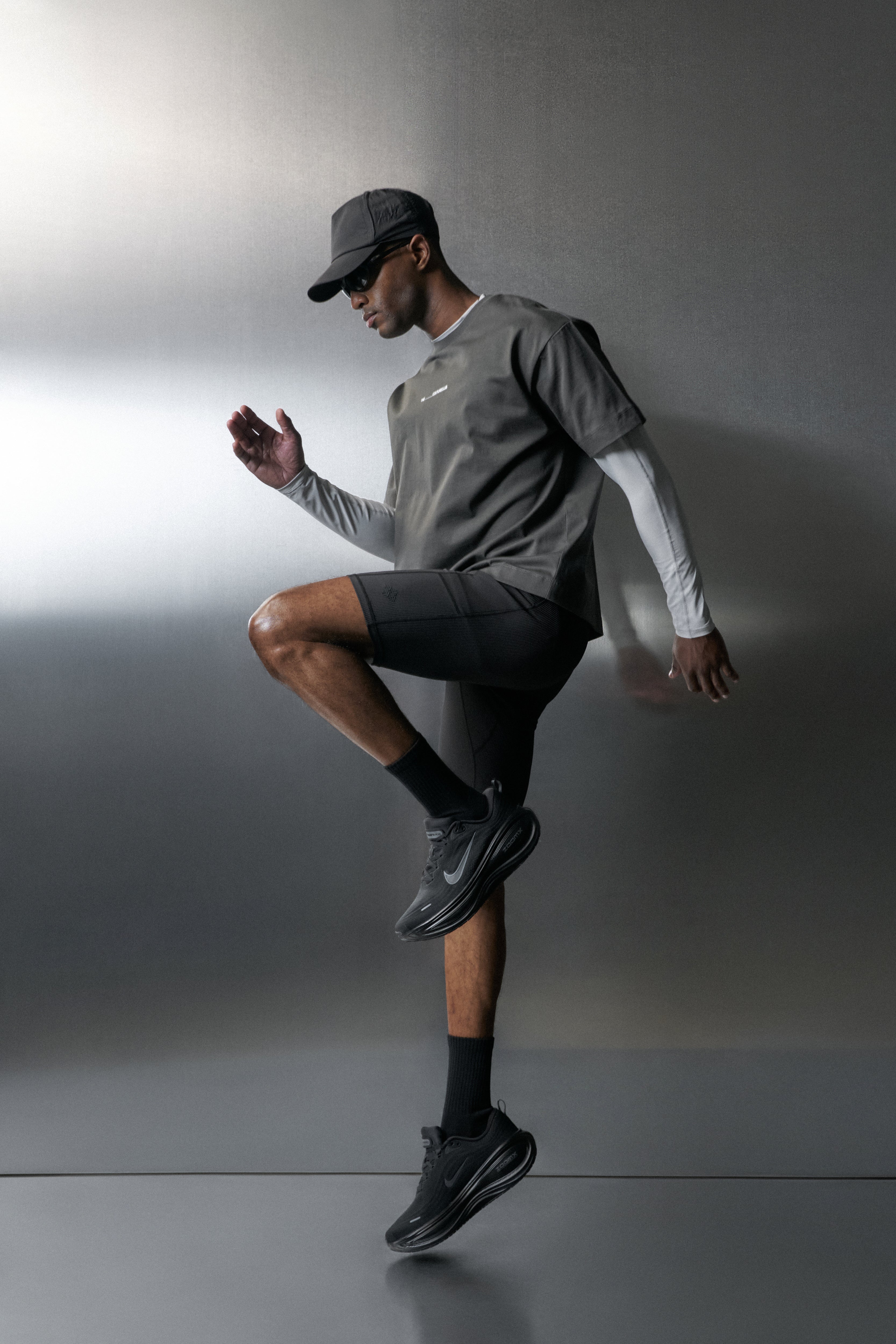 Man in athletic wear posing against a grey background