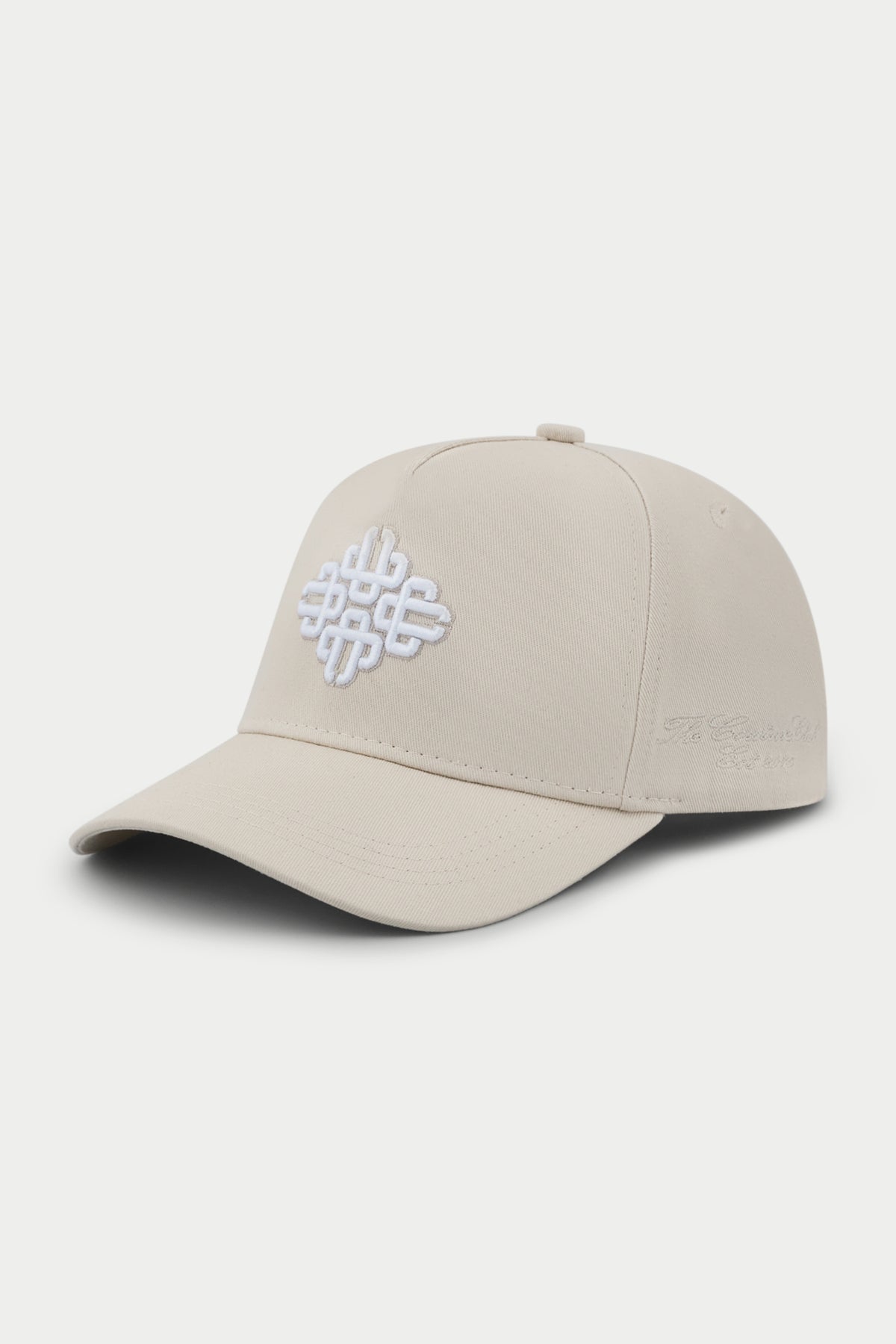 Beige cap with a white embroidered emblem logo on a white background