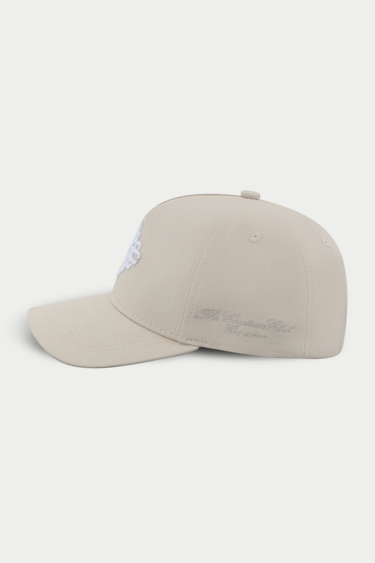 Beige cap with a white embroidered emblem logo on a white background