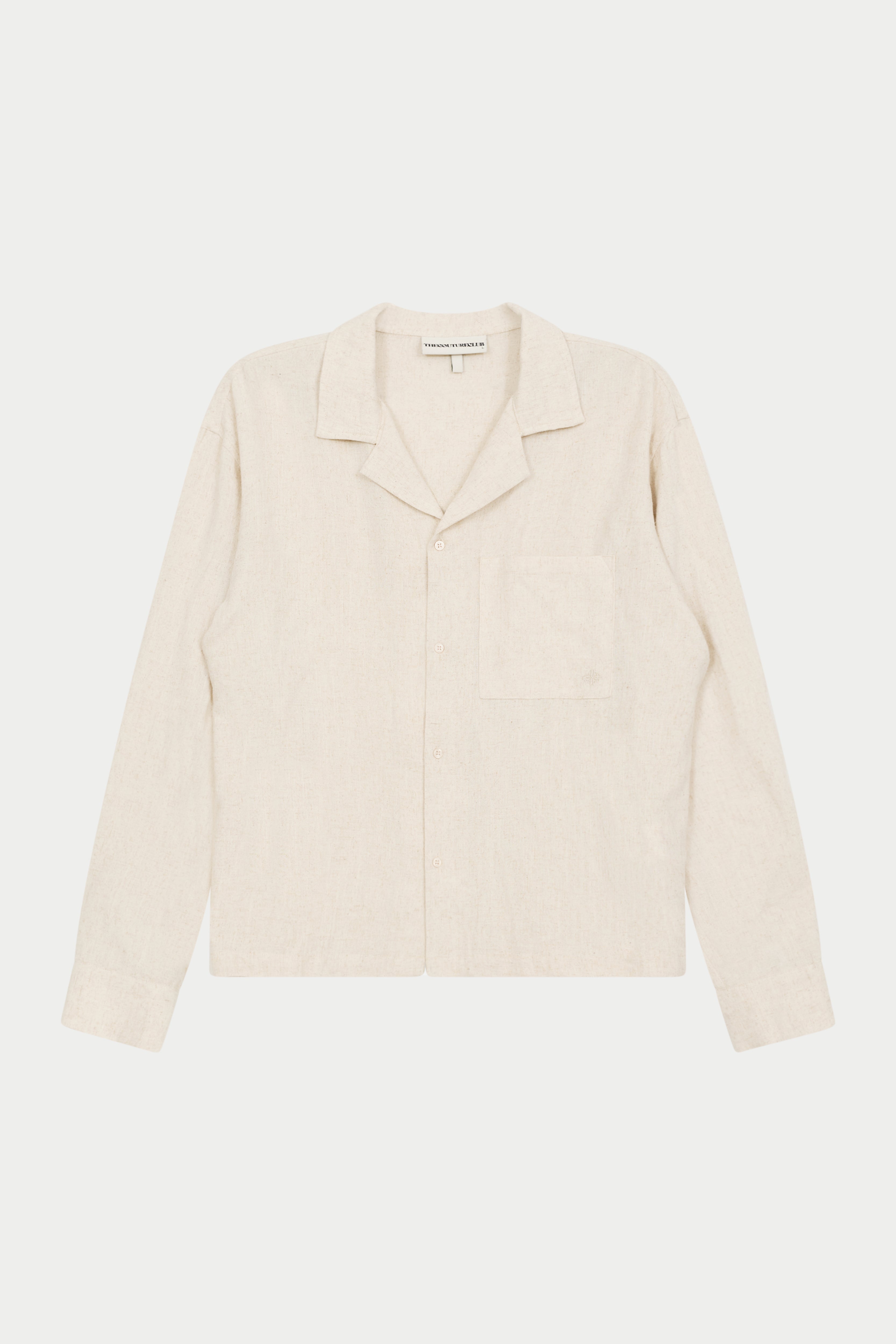 A beige long-sleeved woven shirt with a revere collar, oversized chest pocket, and pearl branded button fastening.