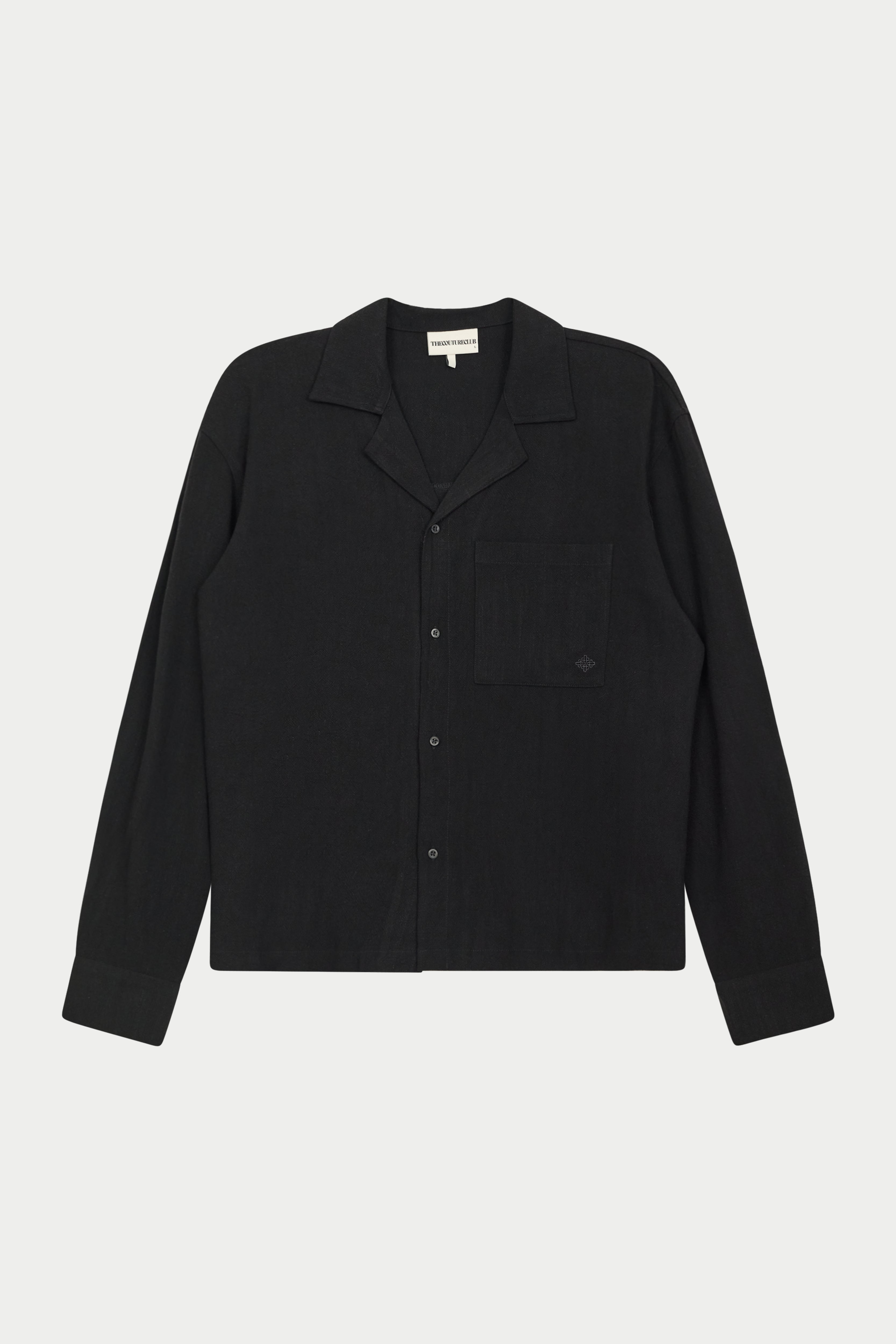 A long-sleeved black woven shirt with a revere collar, oversized chest pocket, and pearl branded button fastening.