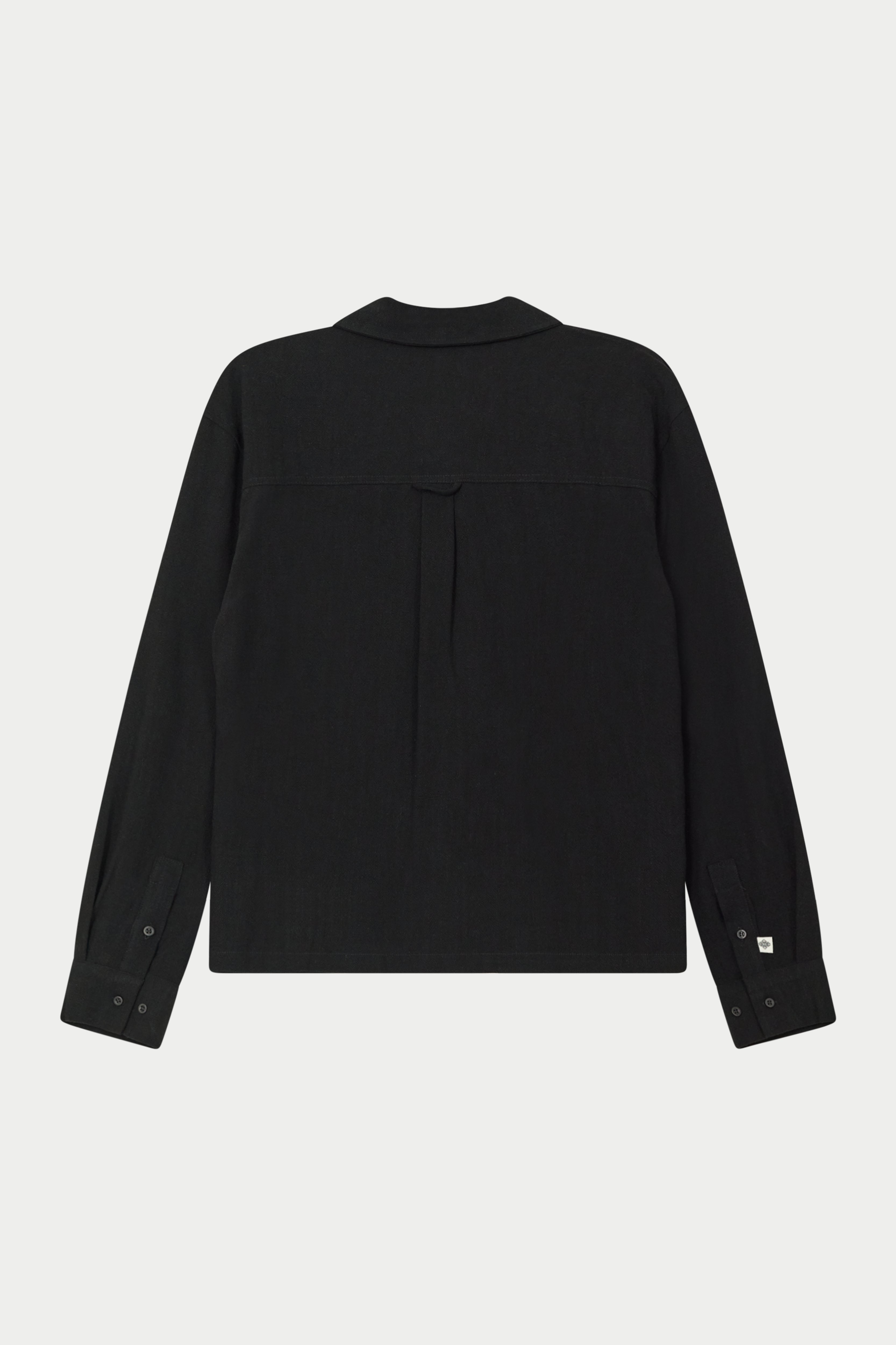 Back image of a long-sleeved black woven long sleeve shirt with a revere collar against a white background.