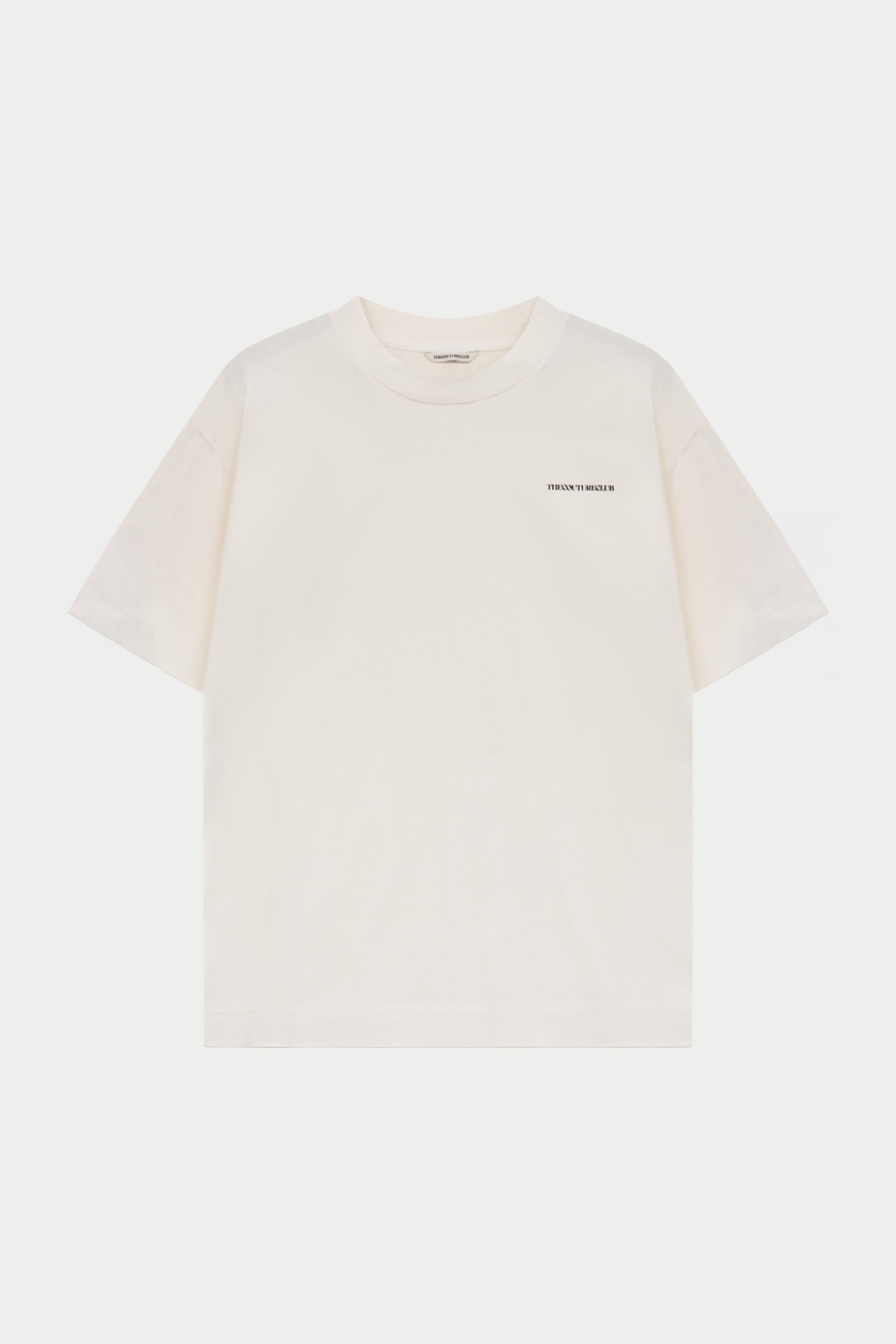 An off-white short-sleeve crewneck t-shirt with a small black text graphic on the left chest, displayed against a solid off-white background.
