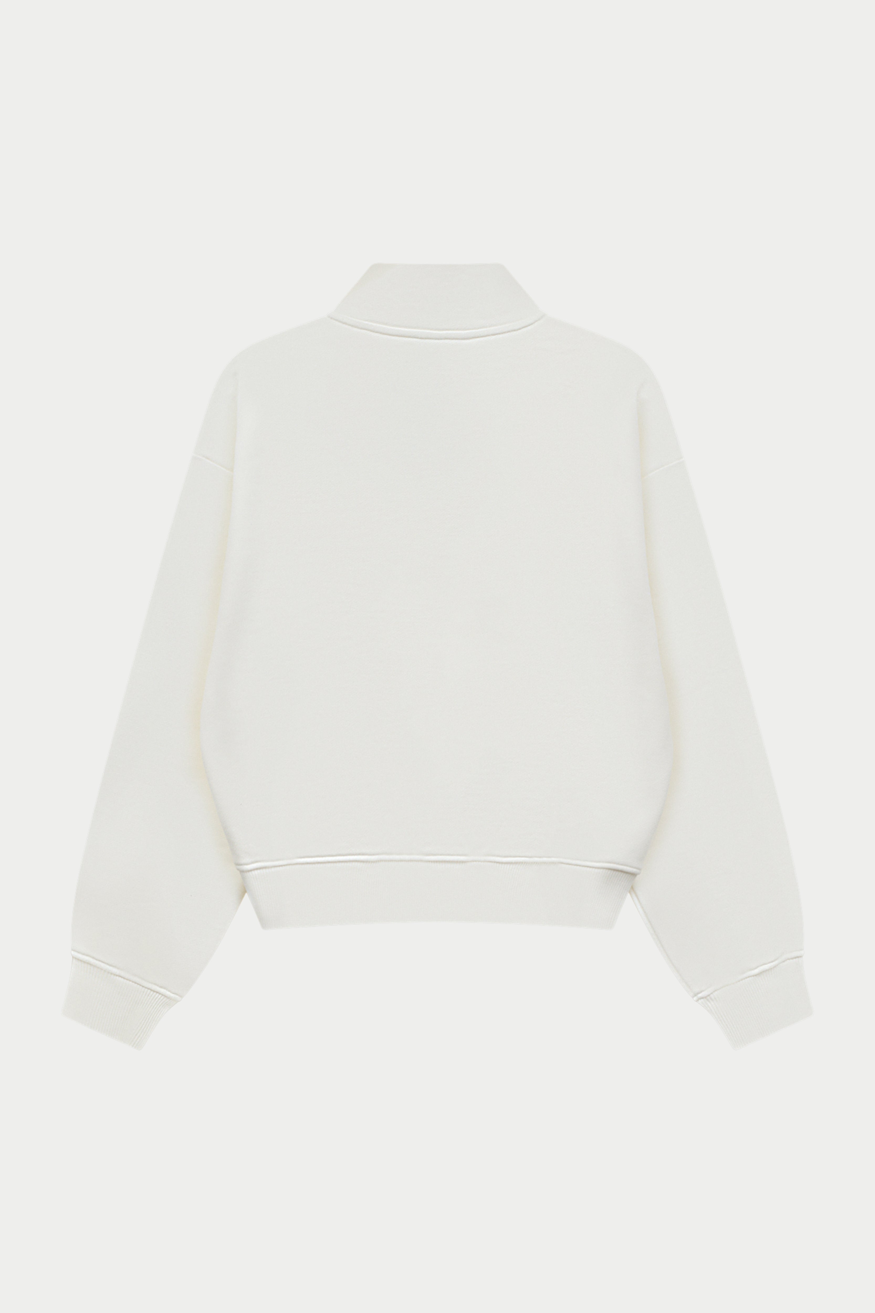 Off white quarter zip sweatshirt on a white background