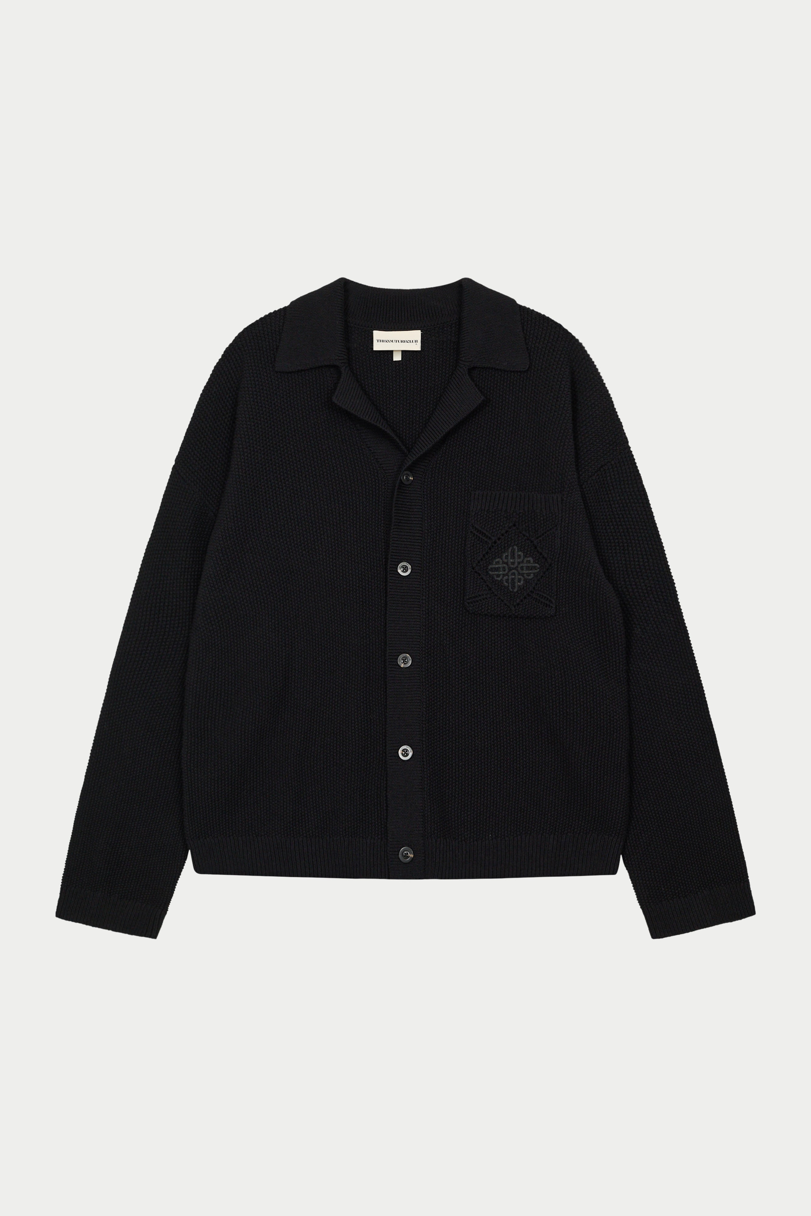 A long-sleeved black shirt with a ribbed collar, crochet knit fabric, and an embroidered emblem on the chest pocket.
