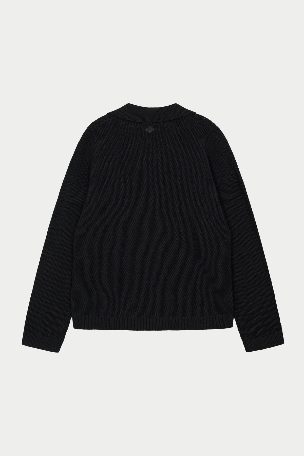 A long-sleeved black crochet knitted shirt against a white background.