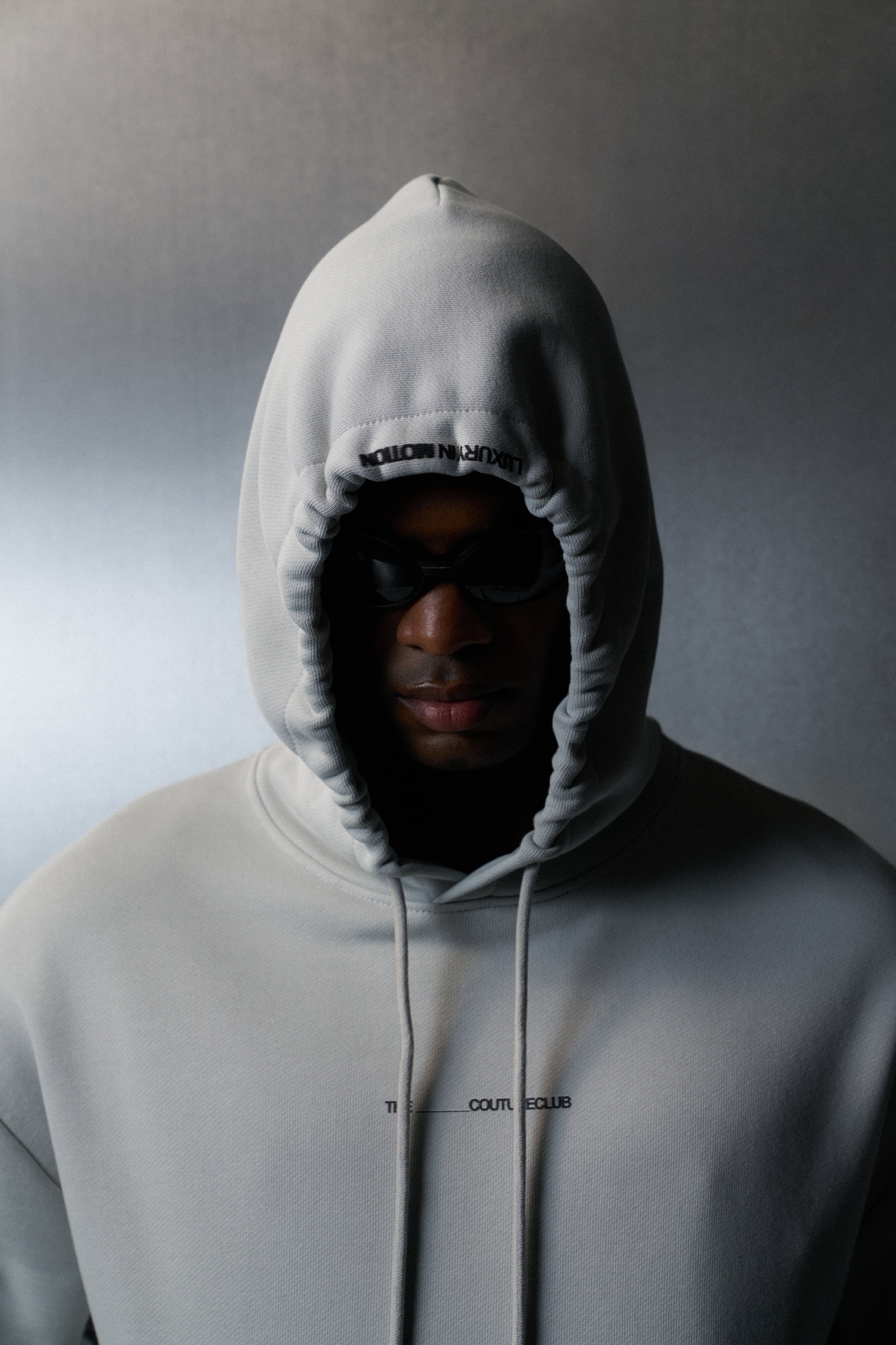 Person wearing a grey hoodie with a blurred background