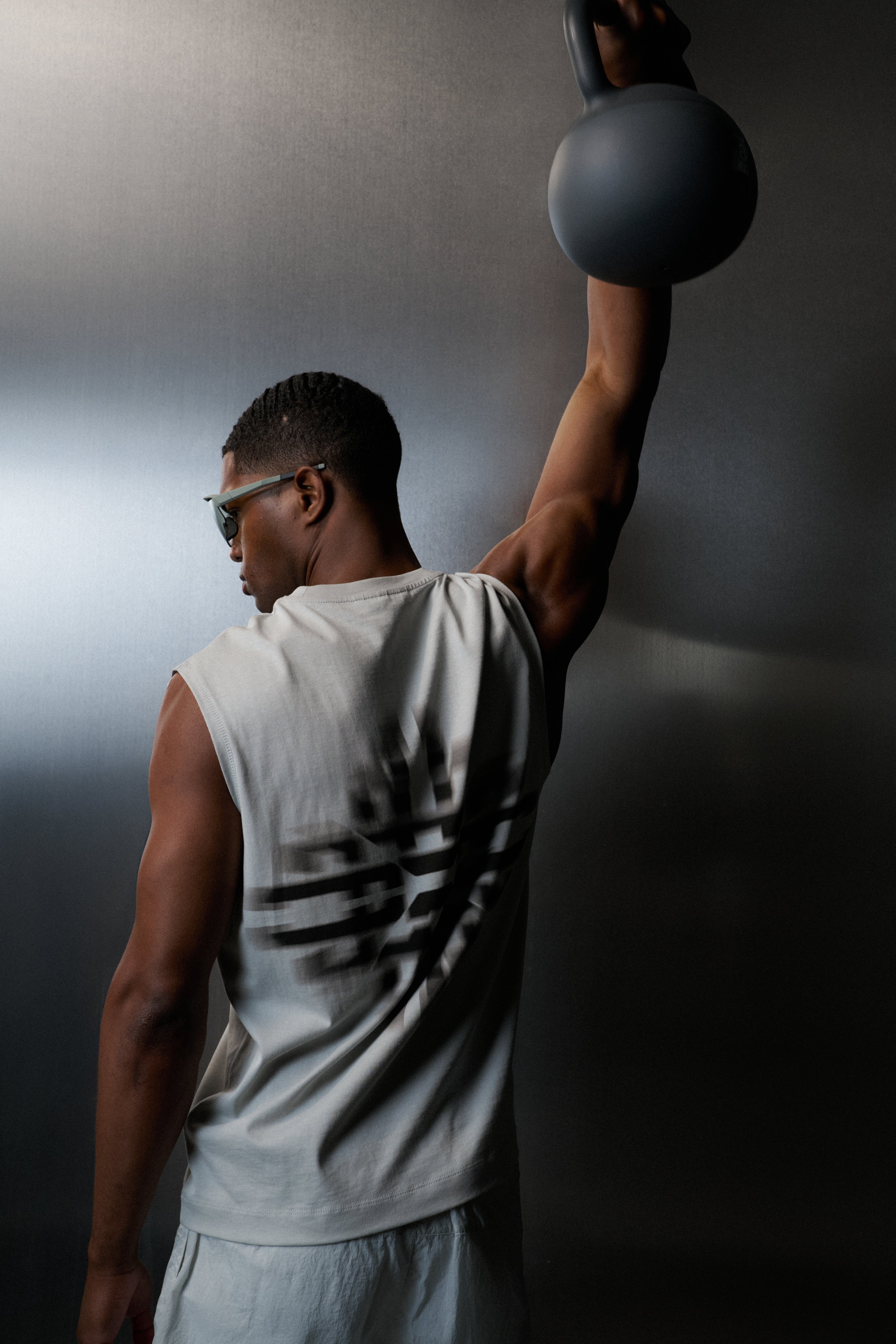 Man lifting a kettlebell against a dark background