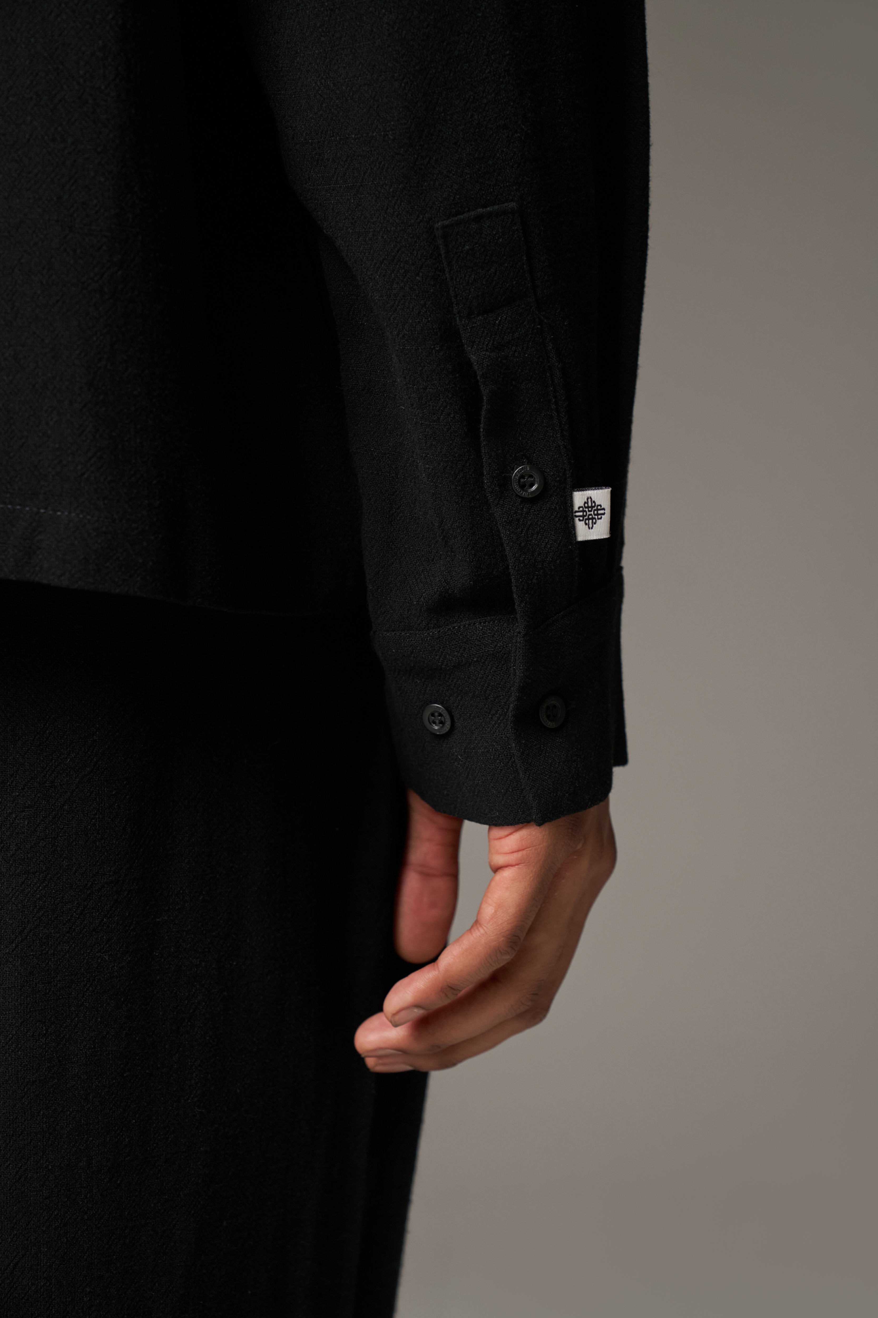 Close up detail shot of a black cuff on a neutral background