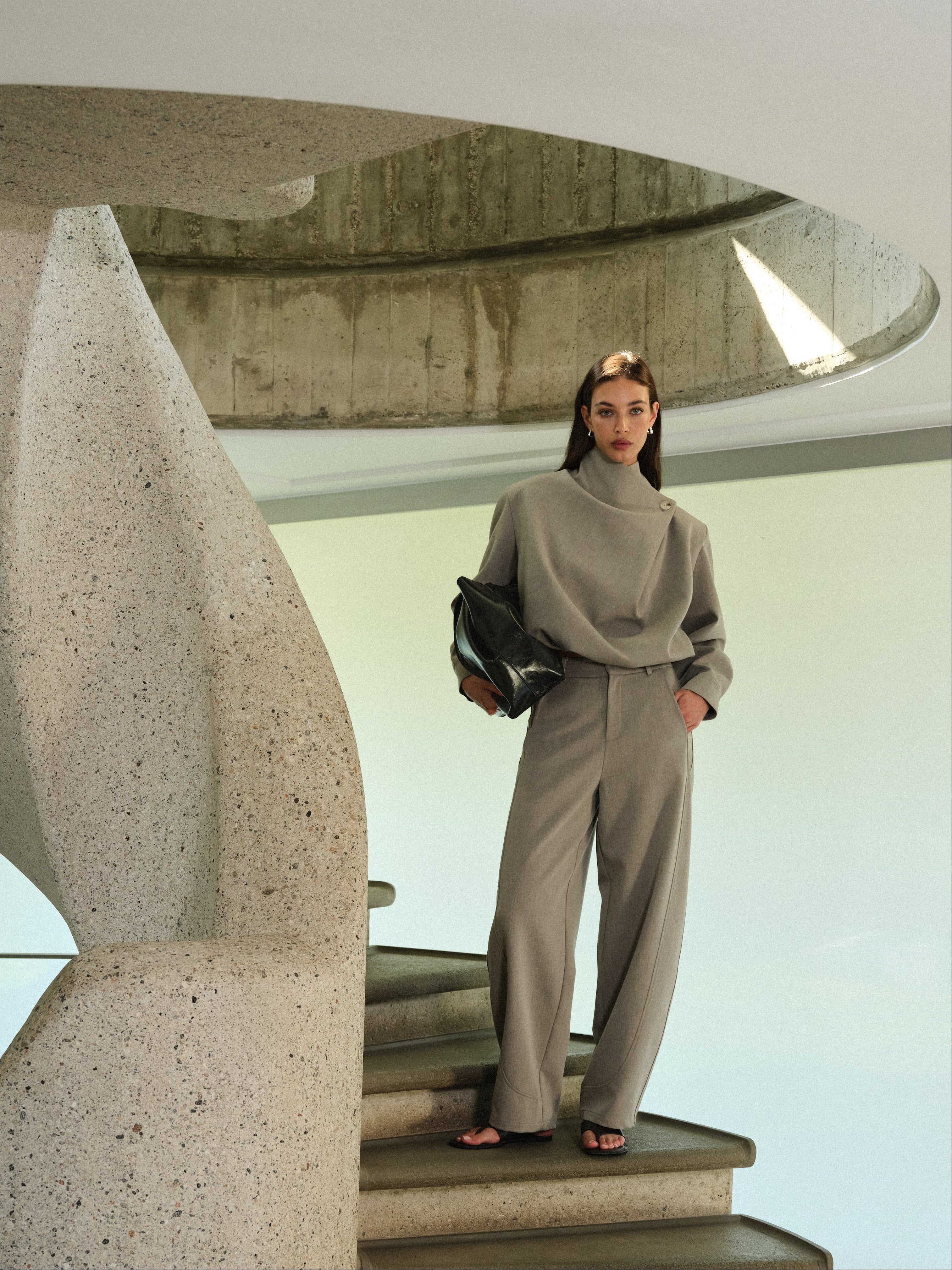 Person standing on a modern staircase with concrete design