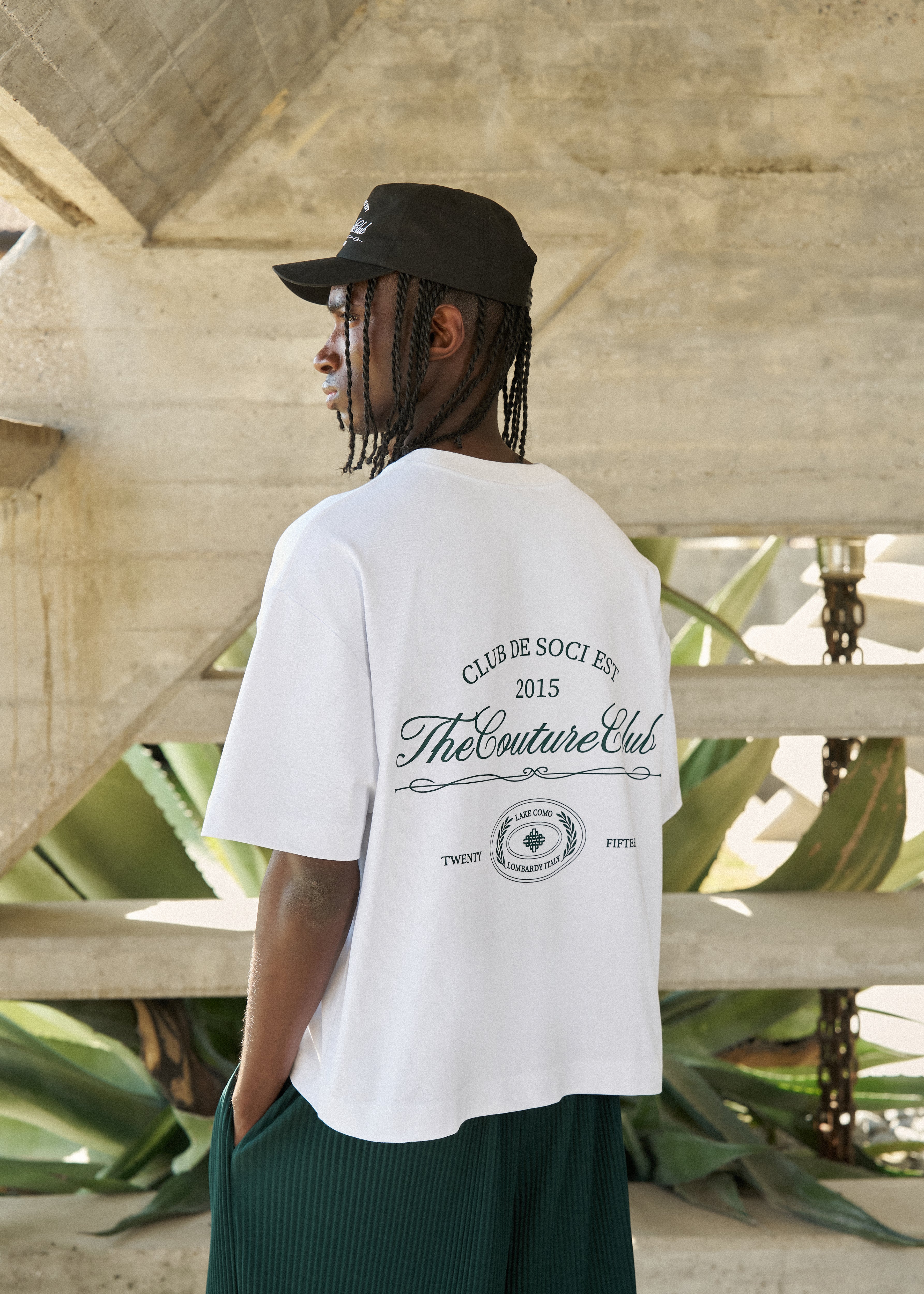 Person wearing a white t-shirt with text and graphics, standing outdoors.