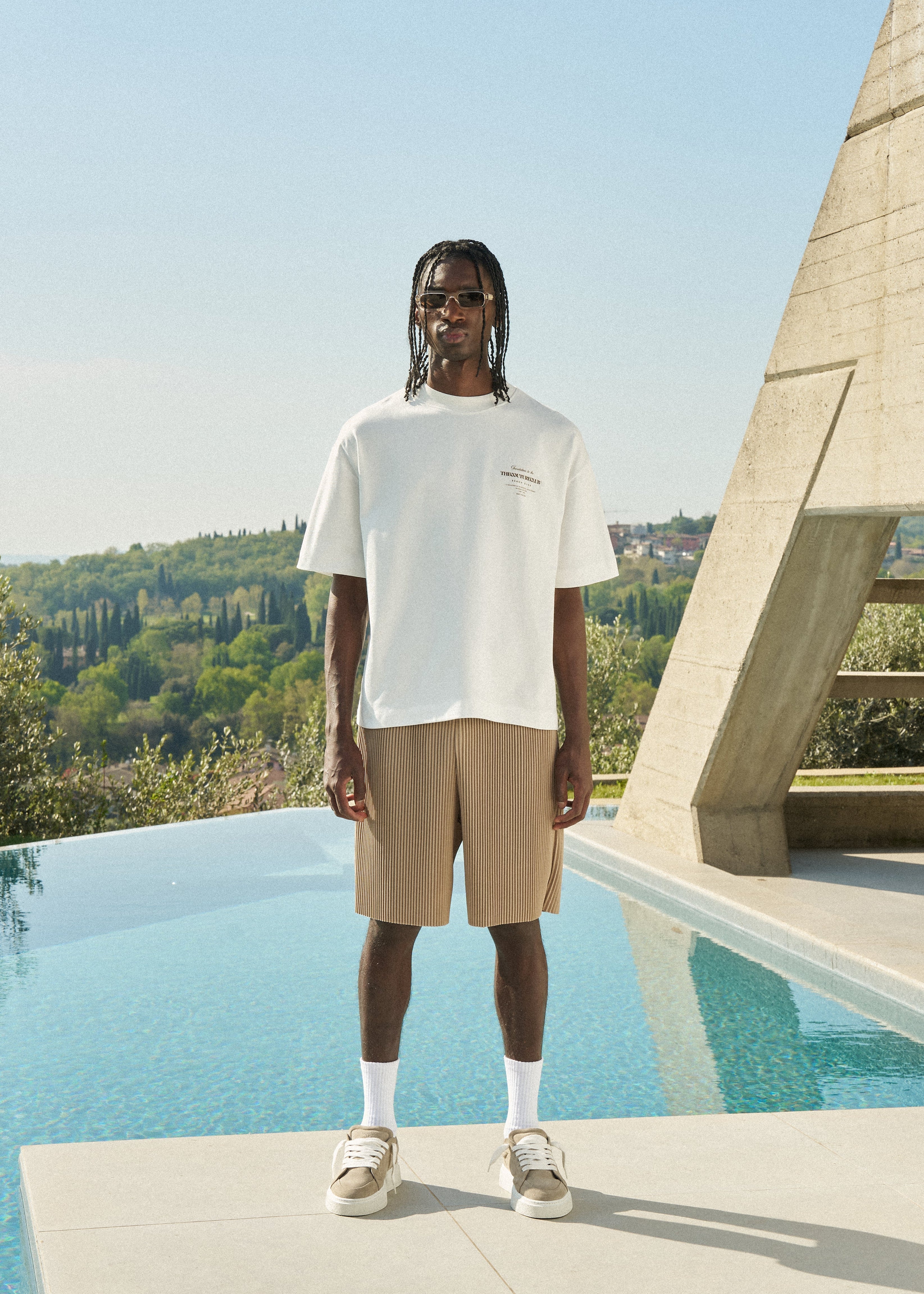 Man standing with white t-shirt and beige shorts