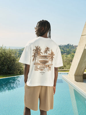 Person wearing a white t-shirt with a graphic design on the back