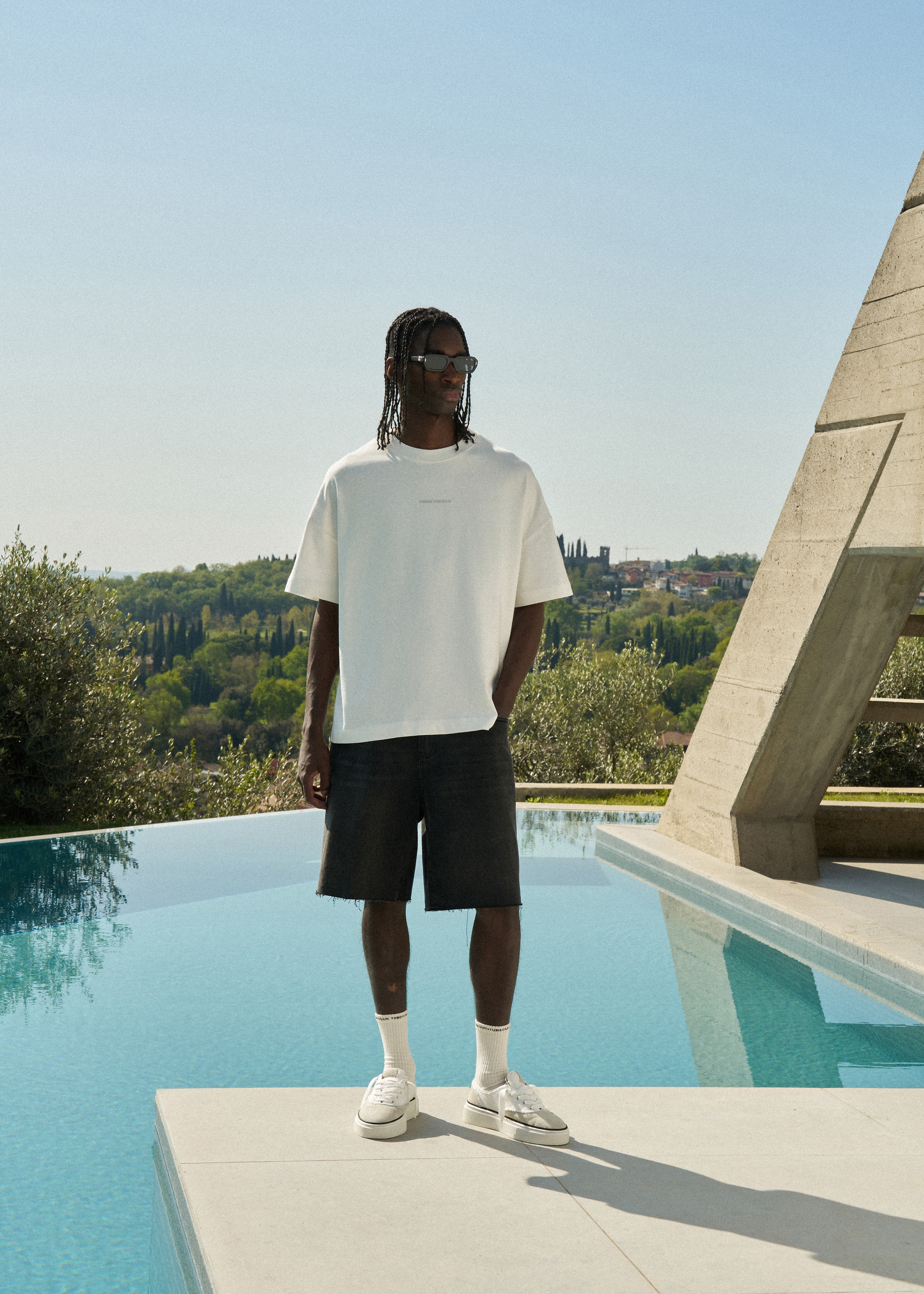 Person wearing white t shirt with black  denim shorts