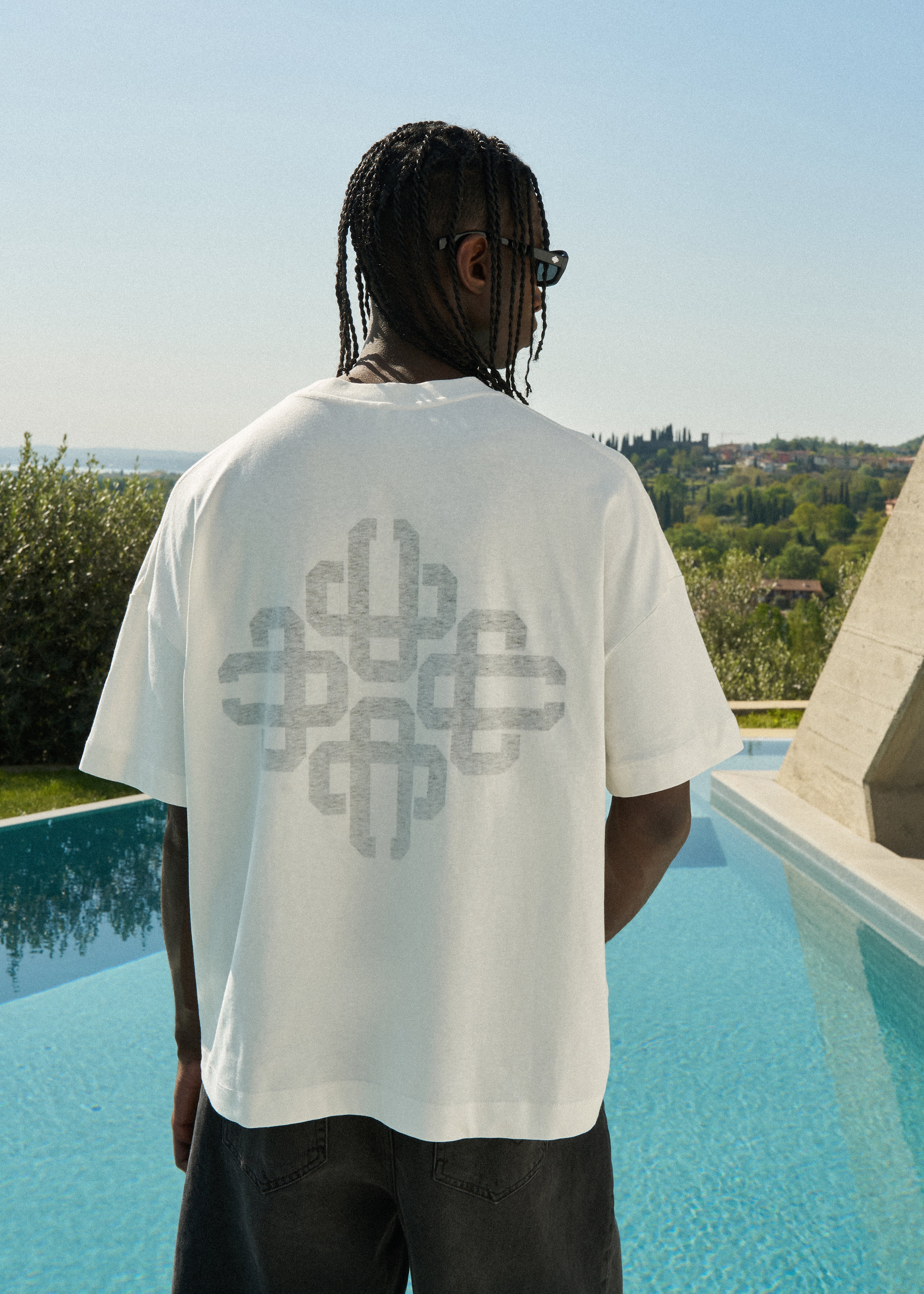 Person wearing a white t-shirt with a geometric design on the back