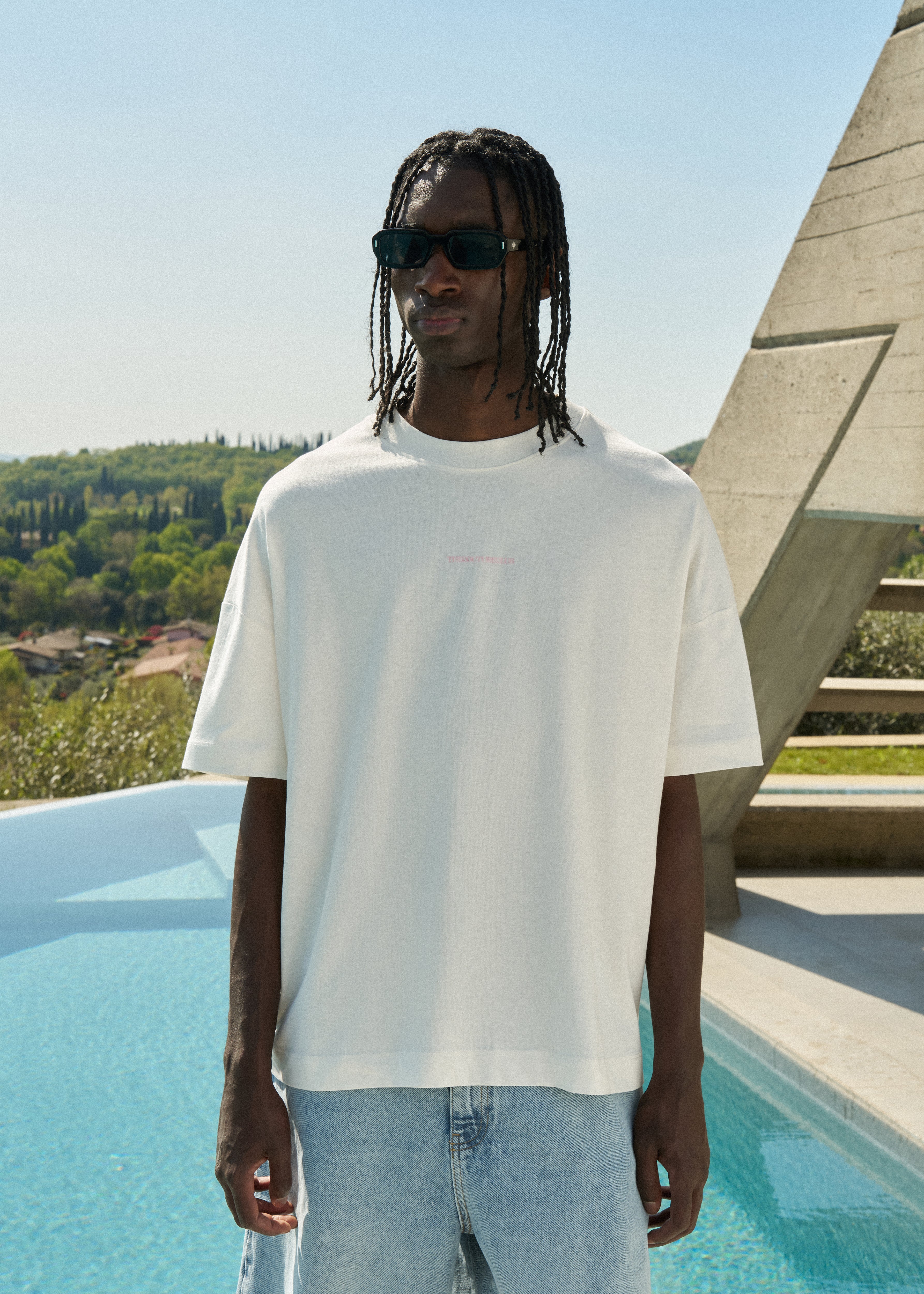 Person wearing a white t-shirt and sunglasses