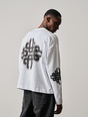 Person wearing a white long-sleeve t-shirt with black text design on a plain background